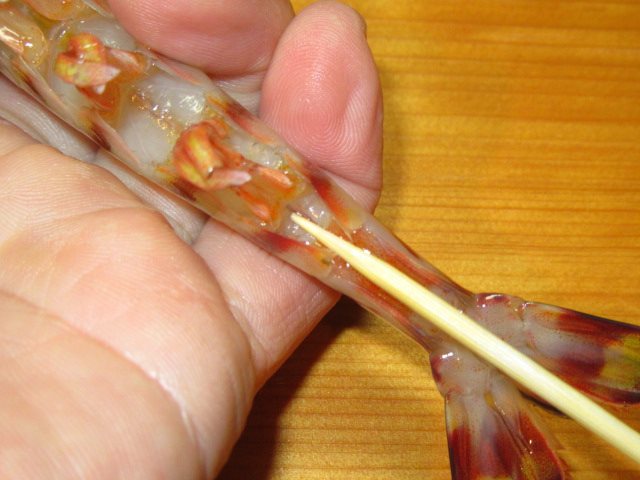 車海老の串打ち方法,才巻えびにのし串を打つ工程,竹串を足の付け根に差し込んでまっすぐに通す工程