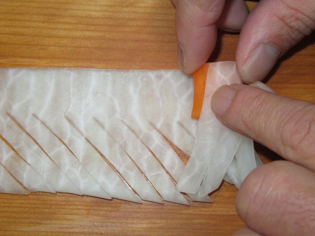 菊花大根の飾り切り方法,大根を人参の芯で巻く工程